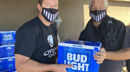 Cavalier Tool President Brian Bendig handing a case of Bud Light to a Cavalier Staff Member.