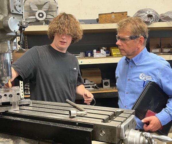 Career Ready Participant Logan is pictured here showing Richard Janik how components are made in the detail room at Cavalier Tool and Manufacturing Ltd.